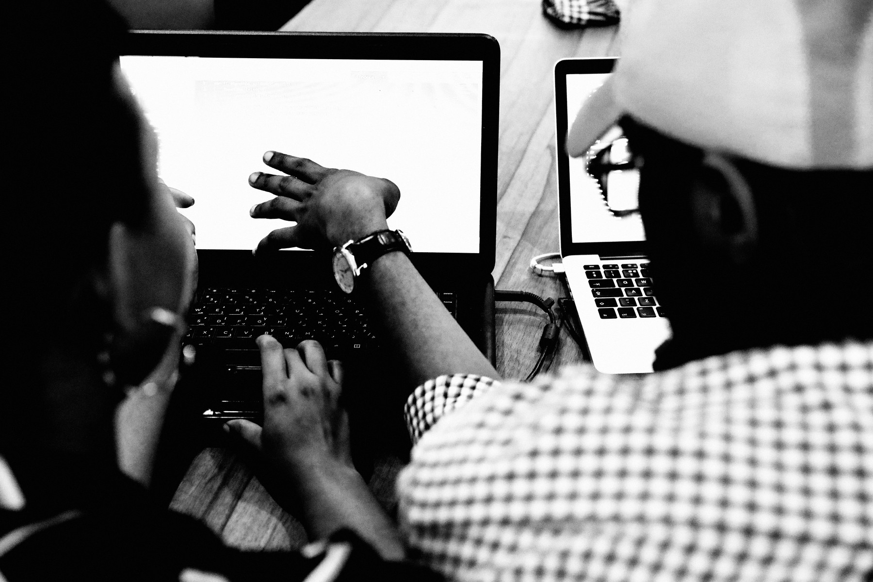 One person coaching another at a laptop